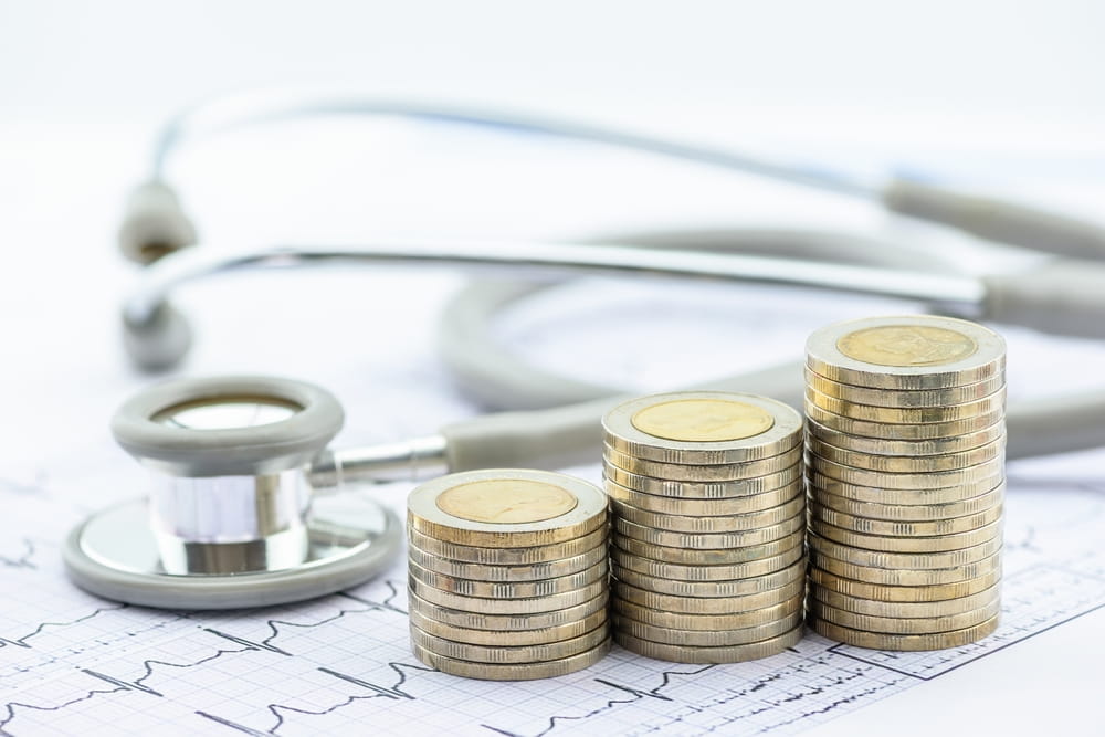 Stacks of coins and stethoscope representing MedPay coverage for medical expenses after Colorado car accident